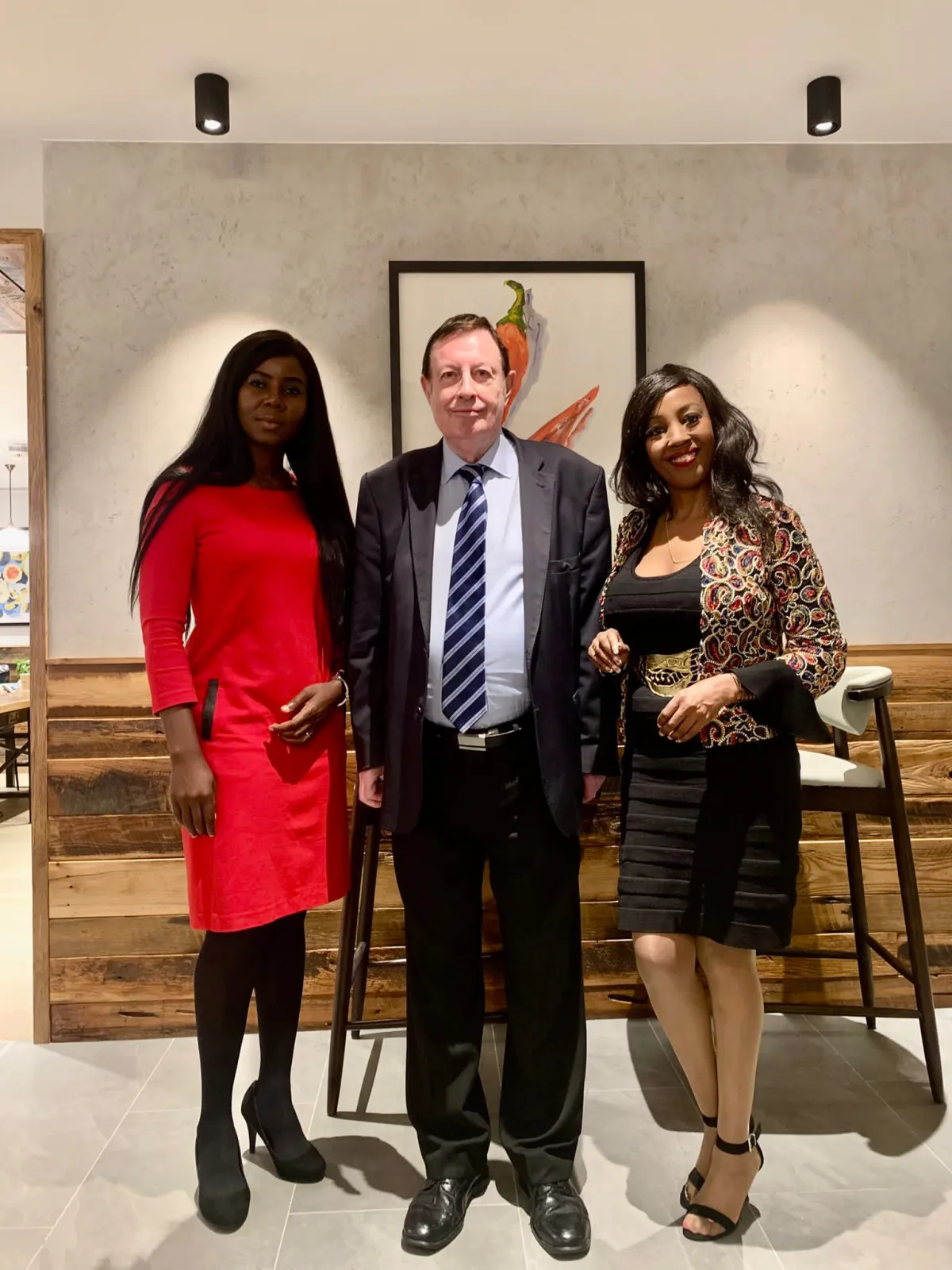 Two women and a man posing together in a restaurant