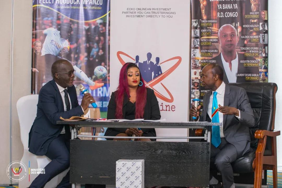 Panel discussion on stage with two speakers and a moderator at a table