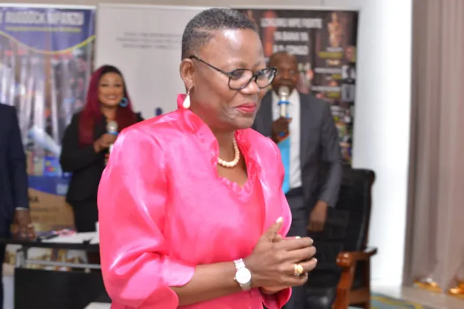 A woman in a pink blouse addressing guests at an AMA event