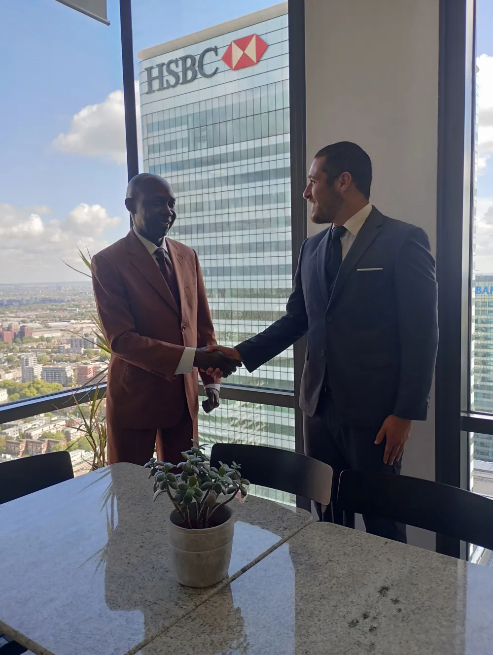 An African business leader shaking hands with an international investor in a London office